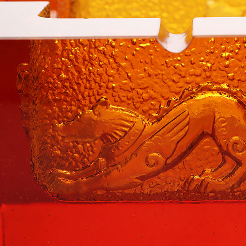 Červený skleněný popelník s nádhernými reliéfními zvířecími vzory